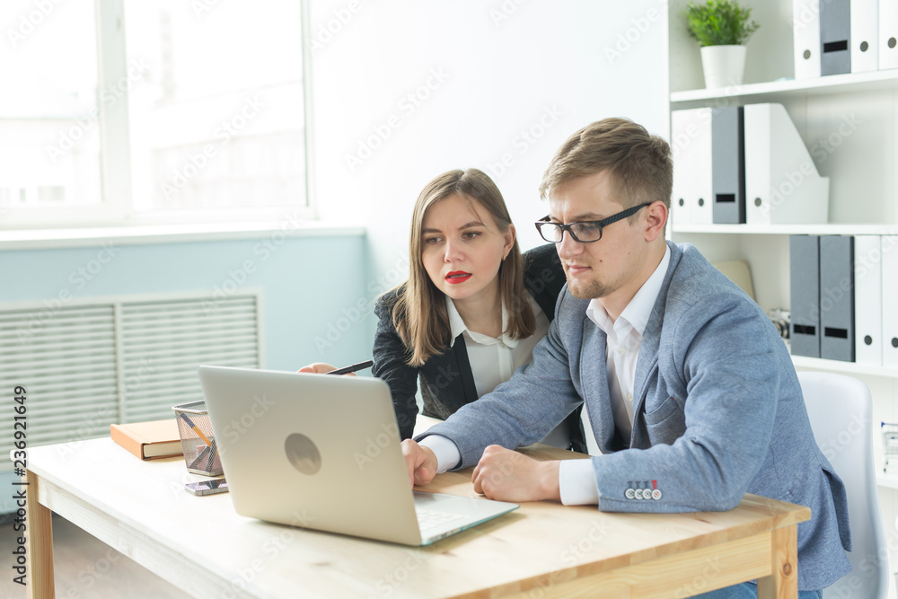 Business, team work and people concept - woman and man are discussing their project together in office Business, team work and people concept - woman and man are discussing their project together in office
