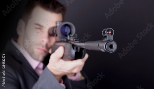 Man in suit with rifle and scope