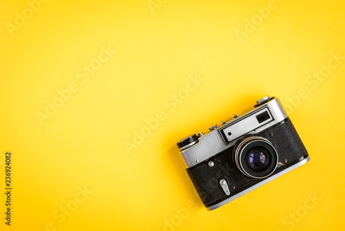 Old camera on yellow background.