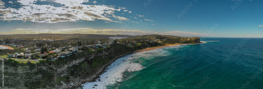 A panoramic view of waterfront homes gracing the cliffs of a northern beaches coastline in Sydney. Sunny, scenic and graceful.
