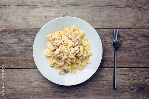 Fresh pasta with chicken, mushrooms and cheese on the rustic wooden background. Selective focus.