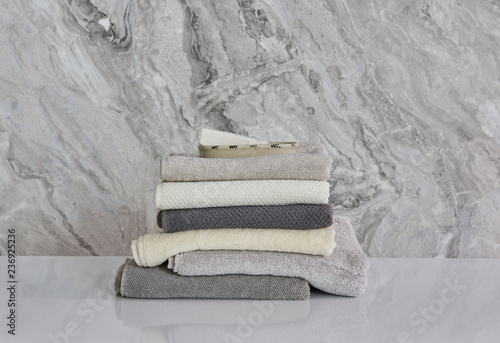 Bath, spa and beauty center grey and white towels on the white table, grey marble background.