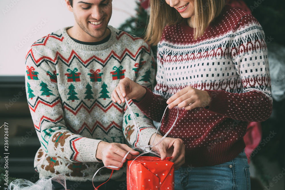 Young woman and man wrap Christmas presents