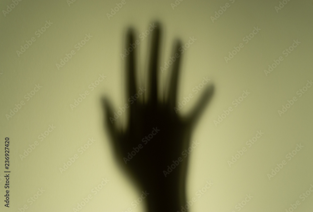 Blurry shadow of the hand on wall background. Safety and motivation concept