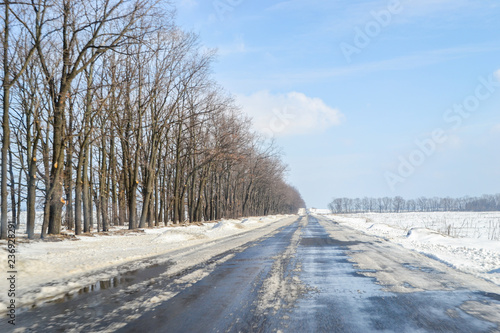 Driving on a snowy road in winter or early spring. View from the car window.