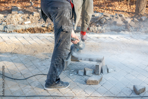 A worker prepares a sidewalk for paving a footpath.