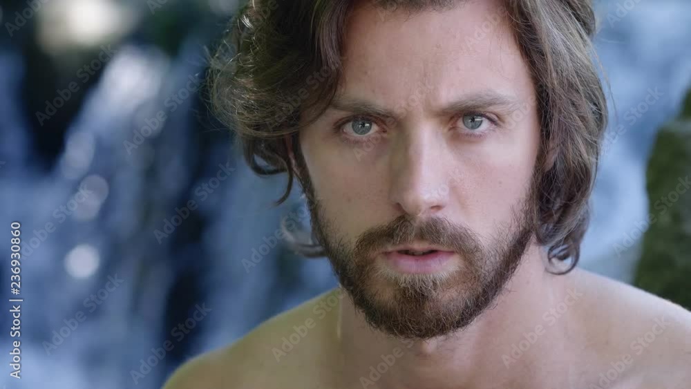 Serious attractive man staring at camera near the waterfall. Nature,wild, Serious attractive man staring at camera near the waterfall. Nature,wild,