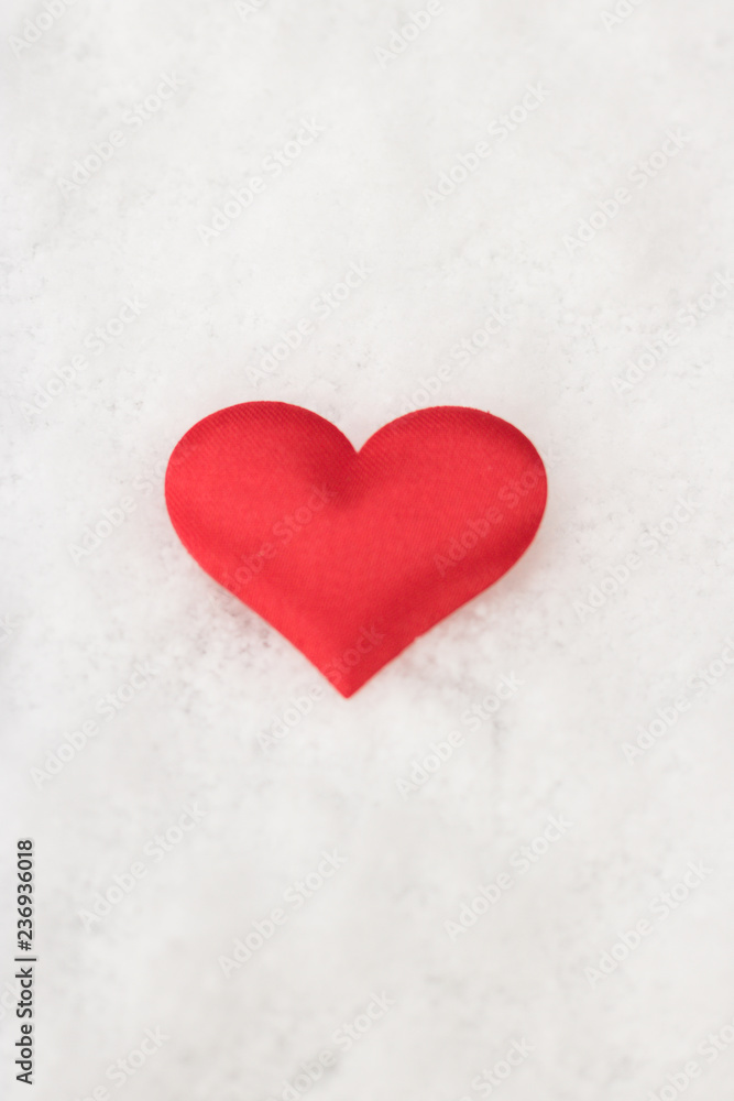Vertical image of red heart is on white snow background. Concept: love. Vertical image of red heart is on white snow background. Concept: love.