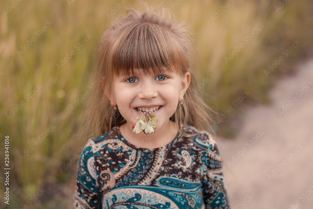 Beautiful girl with long hair at sunset in the forest. Portrait of a girl. Baby with berries in hand at sunset Beautiful girl with long hair at sunset in the forest. Portrait of a girl. Baby with berries in hand at sunset