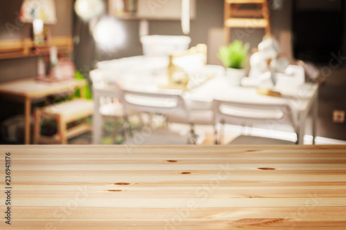 a wooden table with background of blurry interior living room at modern house