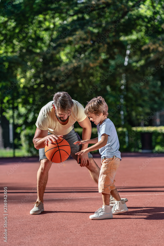 Family playing basketball in summer
