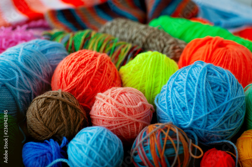 Many multicolored balls of yarn. Yarn for knitting of different colors and types. A lot of balls of yarn collected a bunch. Knitting as a kind of needlework.