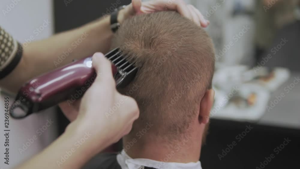 Professional hairdresser cutting hair with hair clipper. Man hairdressing with electric shaver. Male haircut with electric razor. Close-up of hair trimmer hairstyle. Styling with electric trimmer. Professional hairdresser cutting hair with hair clipper. Man hairdressing with electric shaver. Male haircut with electric razor. Close-up of hair trimmer hairstyle. Styling with electric trimmer.
