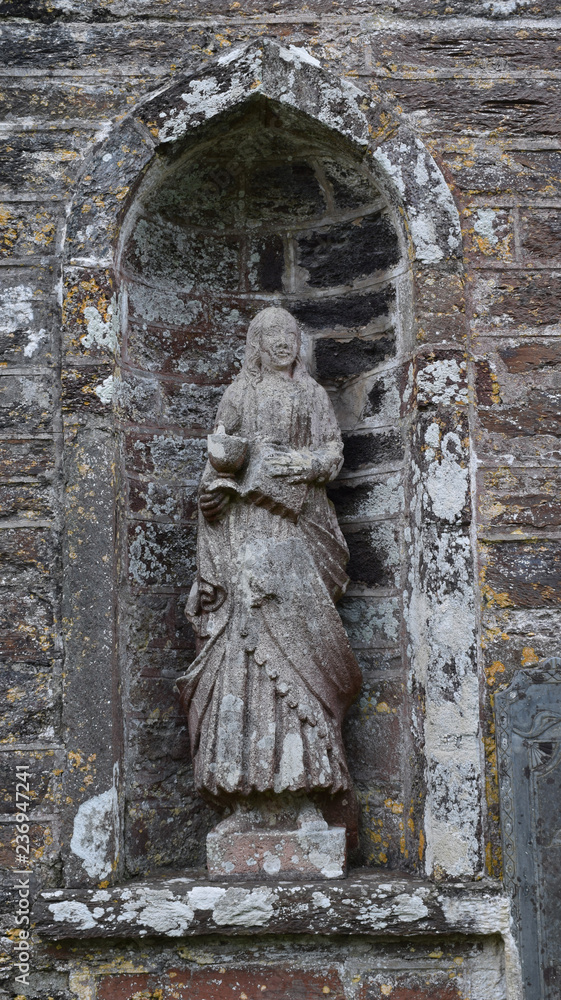 Lichen covered statue in a Cornish Churchyard