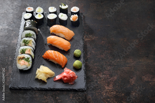 Zestaw sushi. Apetyczne, różnorodne sushi na kamiennym talerzu. Kompozycja na ciemnym tle.