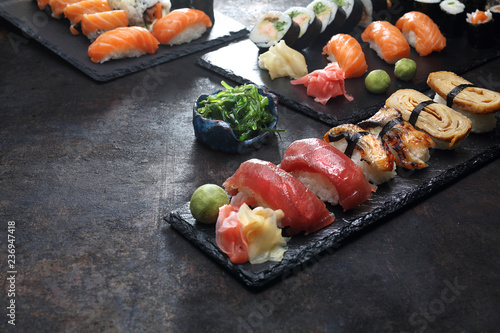 Zestaw sushi. Apetyczne, różnorodne sushi na kamiennym talerzu. Kompozycja na ciemnym tle.