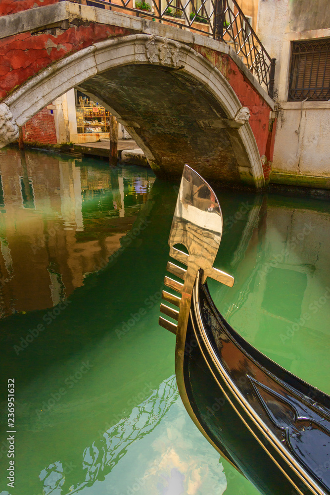 Gondola in venice.Venice: reflections, lights and colors. Particular of the iron prow-head of the gondola. The ornaments on the front of the Gondola represent symbols of Venice. 