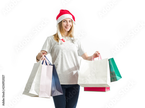 Young woman is holding a package with New Year gifts isolated on a white background. Christmas shopping.