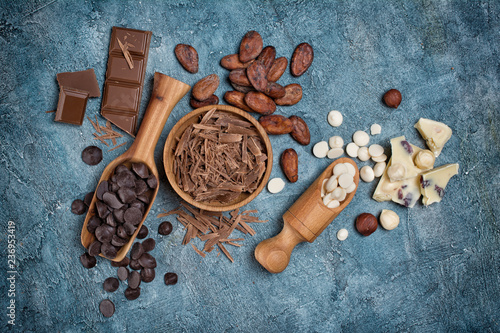 Top view of chocolate chips, bars and drops with cocoa beans for confectionery