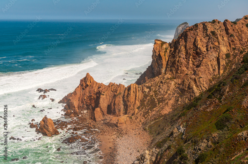 Stunning landscape of cliffs rising from the turquoise waters of the Ocean on a sunny summer day. Cape Roca (Cabo da Roca), the most western point of Europe in Sintra, Portugal.