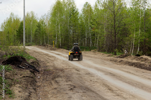 ATV rides along the mountain road (rear view)