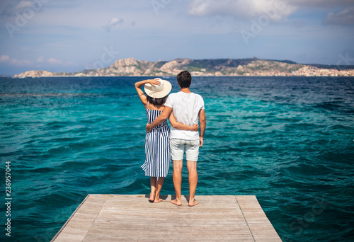Canvas Print Young couple in love enjoy beautiful sea landscape on pier in Italy