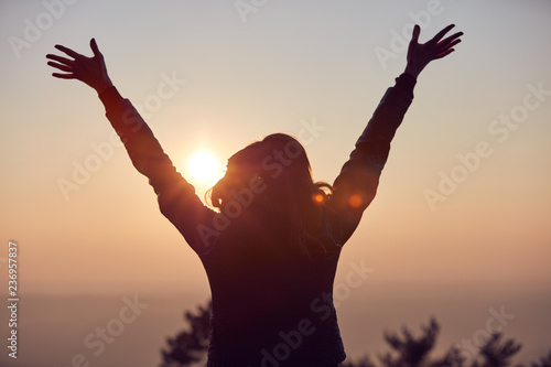 Woman with arms wide open enjoying the sunrise / sunset time. #236957837