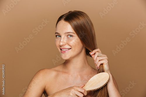 Obraz na plátně Beauty image of young shirtless woman smiling and brushing her with long hair, i