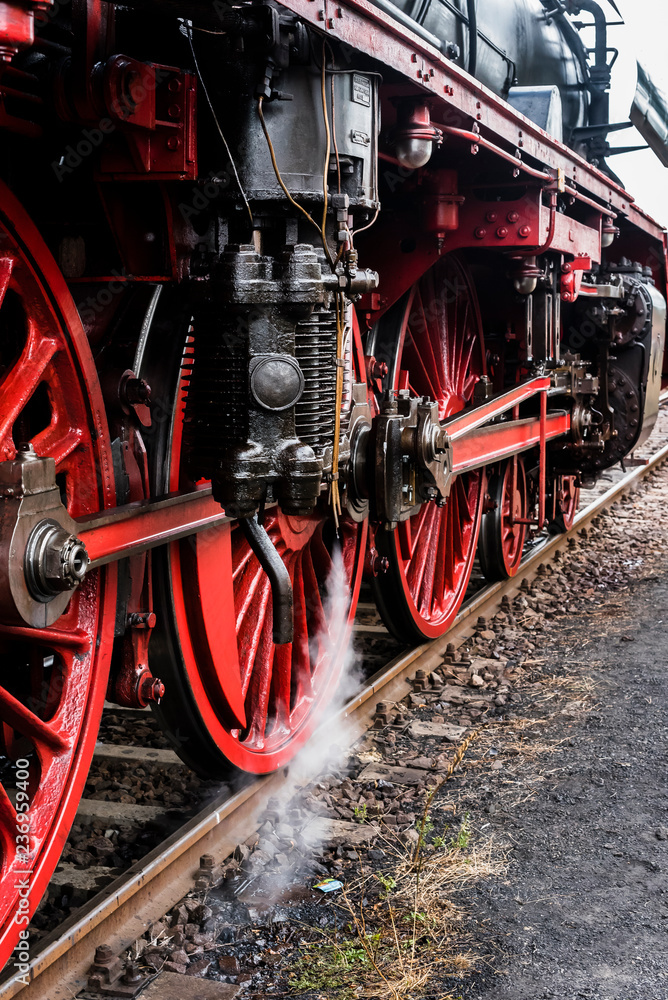 Detail of a steam locomotive with white Steam, white Steam, Detail of Big red Wheels, rod Drive