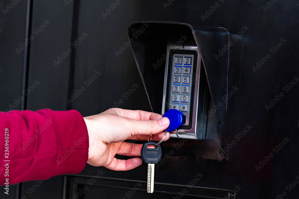 A woman puts the chip to the intercom to open the door and go into the  entrance. Electronic door guard Stock Photo | Adobe Stock