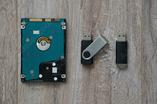 Wallpaper Mural Hard Disk Drive (HDD) on Solid State Drive (SSD) with two flash drives on brown wooden background Torontodigital.ca