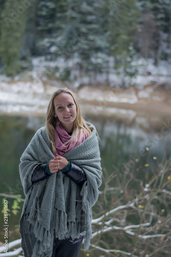  Girl near the winter lake wrapped in a blanket. Snowy forest Portrait of a blonde in nature © Hanna