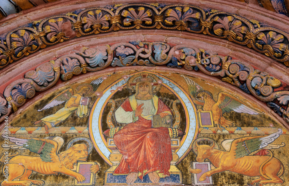 Jesus Christ surrounded by Four Evangelists (represented as winged angel, lion, ox and eagle) and the fresco above the entrance to the Church of Saint Faith in Selestat, France. 