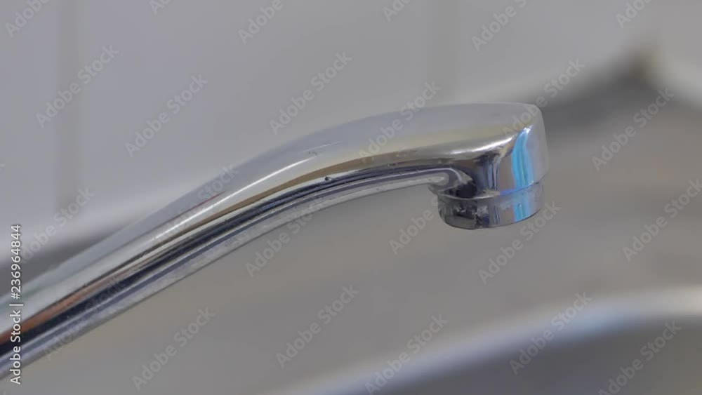 Closeup of water falling from the a leaking tap in slow motion. Closeup of water falling from the a leaking tap in slow motion.