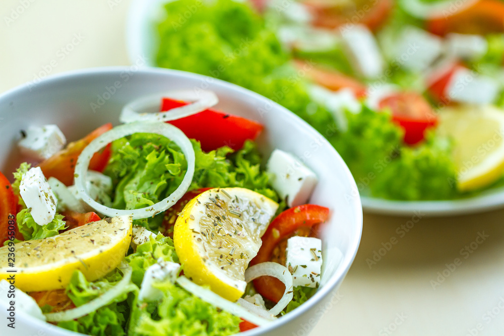 Fresh, healthy vegetable salad with feta cheese and lemon wedges in a plate. Healthy and right food. Diet Fresh, healthy vegetable salad with feta cheese and lemon wedges in a plate. Healthy and right food. Diet