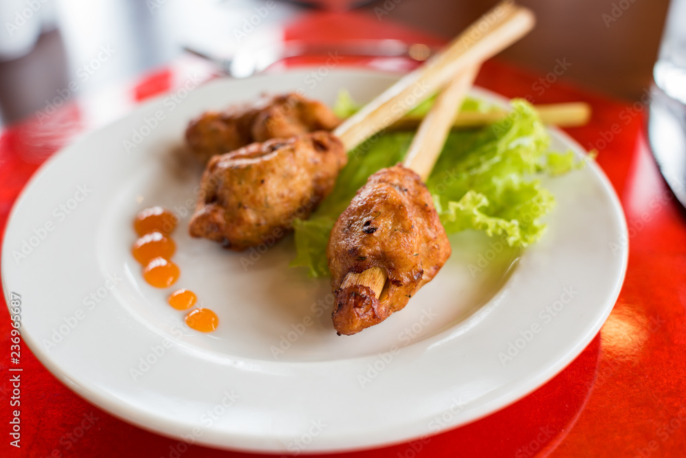 Meat on a lemongrass stick served with lettuce and hot chilli sauce Meat on a lemongrass stick served with lettuce and hot chilli sauce