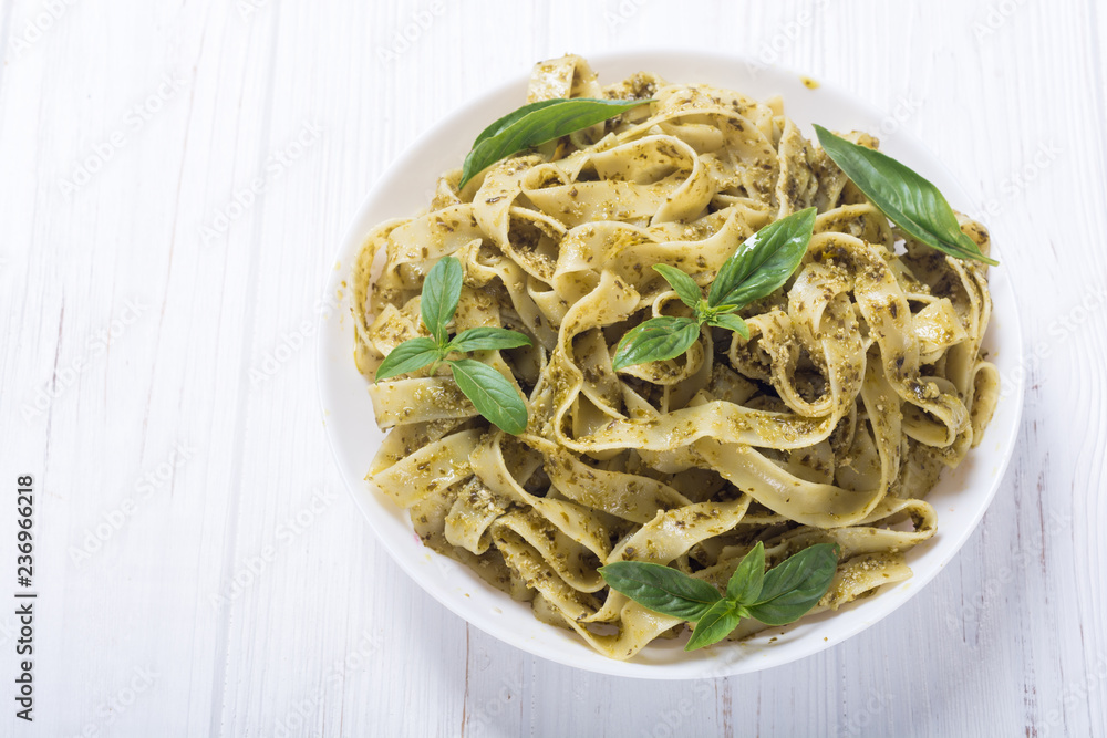 Pasta tagliatelle with green sauce pesto . Italian food background