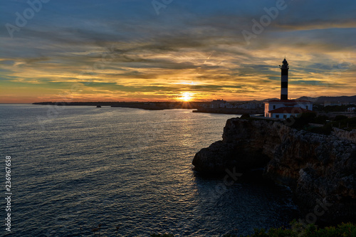 Lighthouse at sunset under a splendid sky of colors and a calm sea. Mediterranean sea in Spain. Baleares, Mallorca
