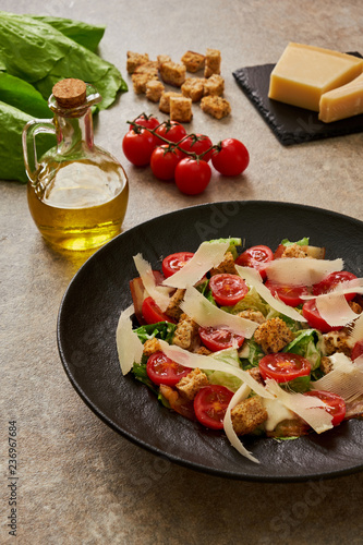 Caesar salad on a black plate, ingredients