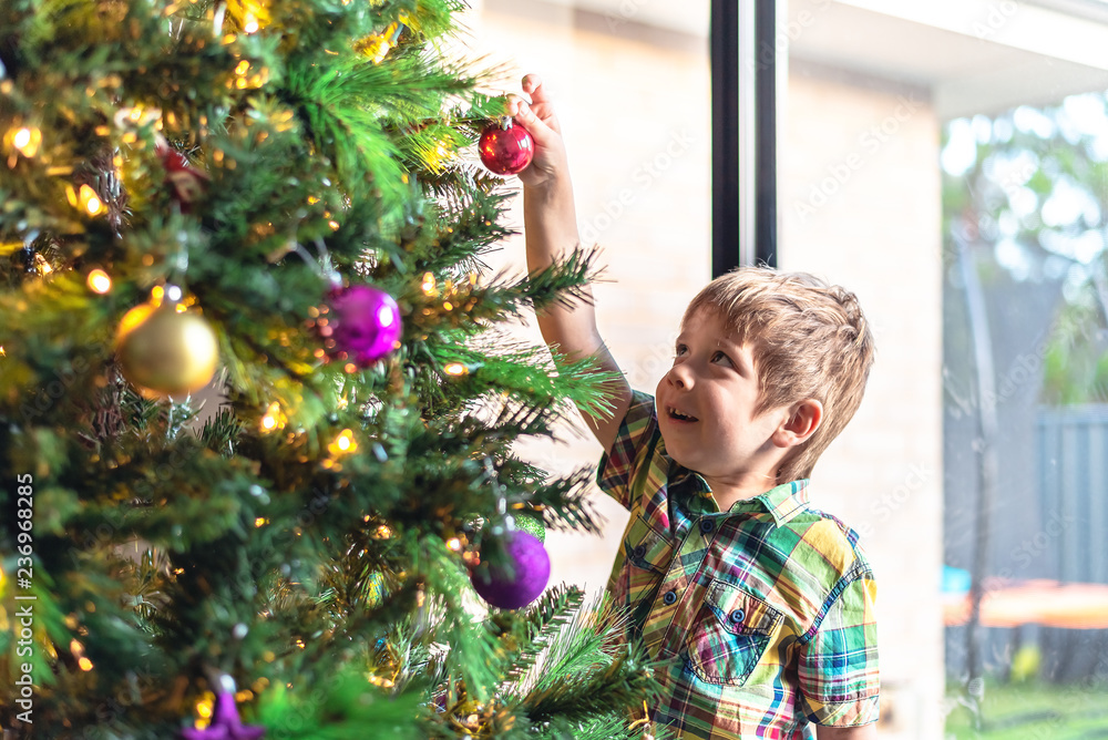 Child decorating Christmas tree Child decorating Christmas tree