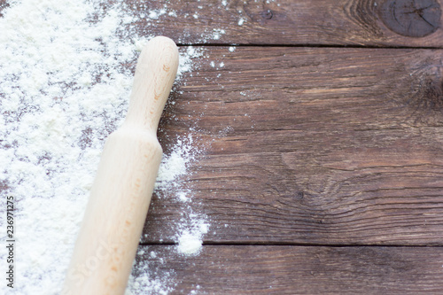 white wheat flour and rolling pin on wooden background