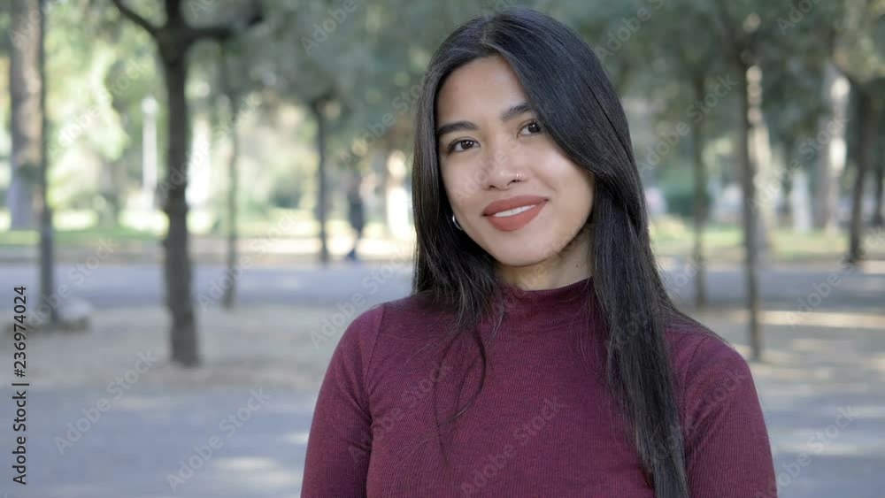 Sensual young asian woman in the park smiling at camera- slow motion Sensual young asian woman in the park smiling at camera- slow motion