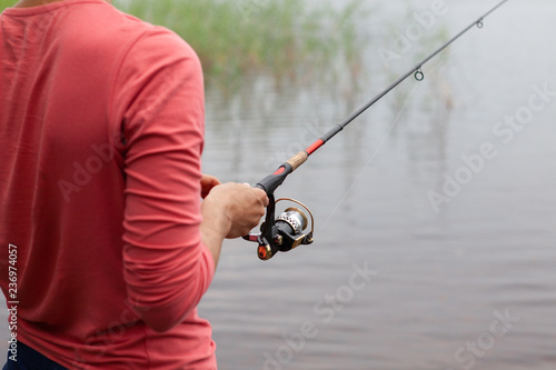 Fishing rod with a fishing reel in a woman's hand