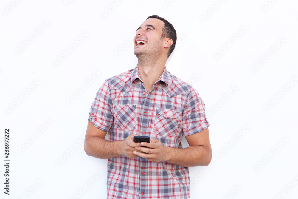 older man laughing with mobile phone and looking up against isolated white background older man laughing with mobile phone and looking up against isolated white background