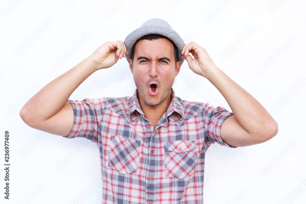 Naklejka premium surprised latin man with hat and open mouth against isolated white background