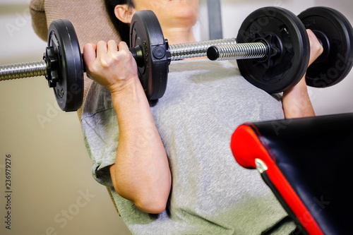 Young woman doing exercise with dumbbell in gym