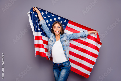 Cute sweet lovely excited smiling lady emigrant worker  holding USA american flag behind back, isolated over grey background photo