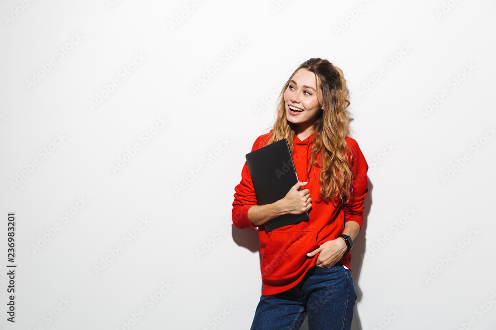 Image of adorable woman 20s wearing red sweatshirt holding gray laptop, isolated over white background Image of adorable woman 20s wearing red sweatshirt holding gray laptop, isolated over white background