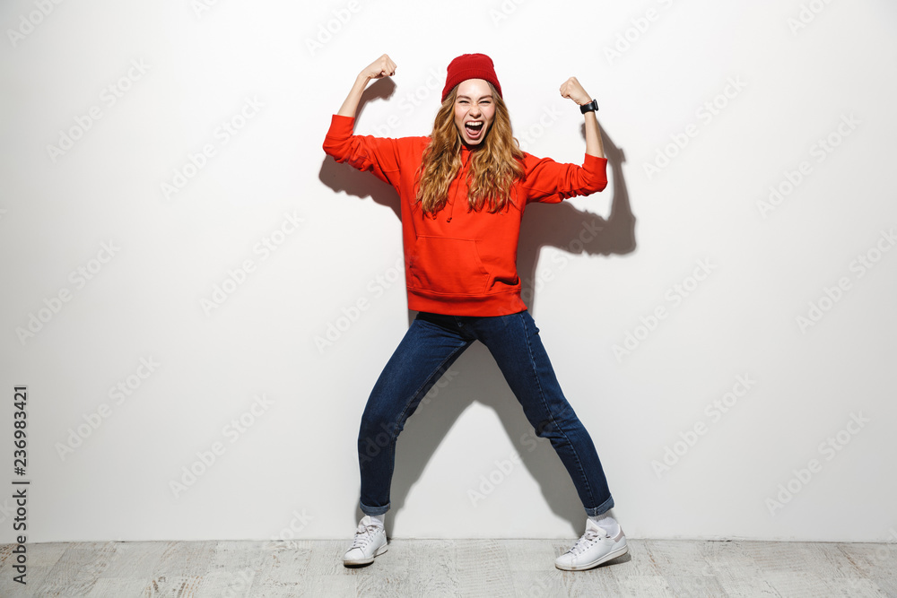Full length photo of optimistic woman 20s wearing red clothes laughing while standing, isolated over white background