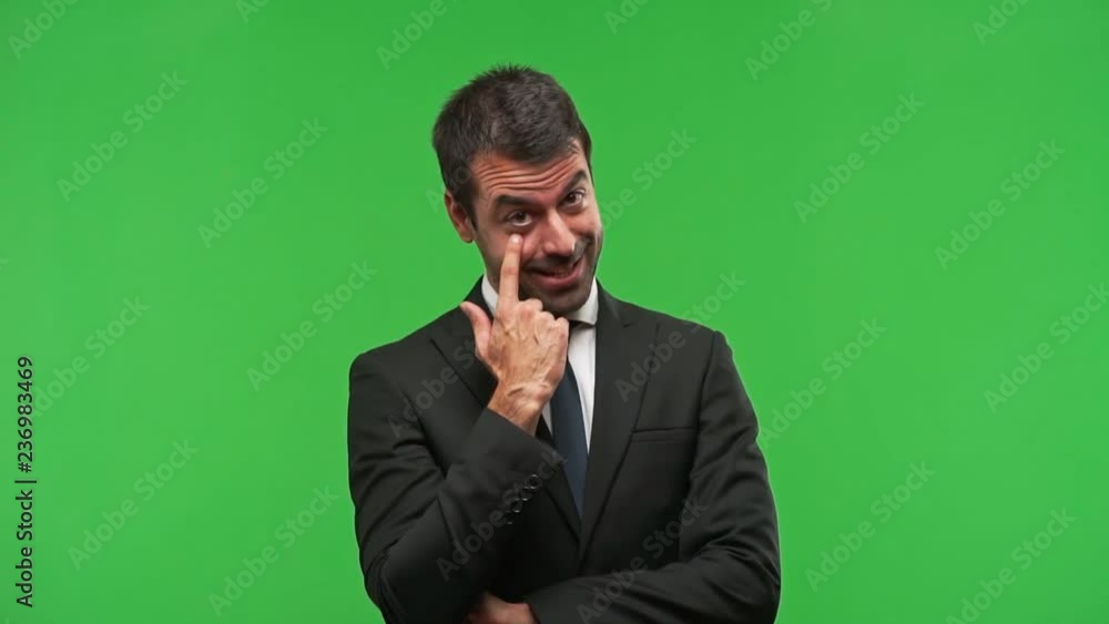 business man standing and looking to the front opening the eye with finger business man standing and looking to the front opening the eye with finger